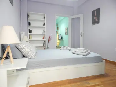 a white bedroom with a large bed and a lamp at 2 Bed Flat - Sleeps 4 - Pets - Parking - Wifi in Athens