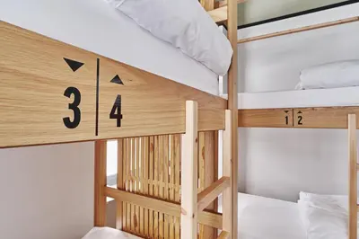 a wooden bunk bed with a number on it at When in Athens Hostel in Athens
