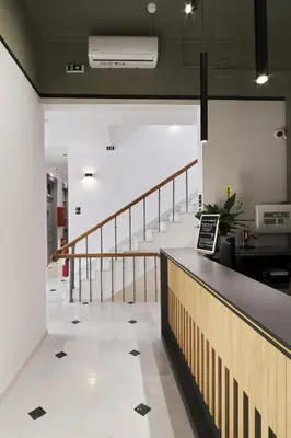 a lobby with a staircase and a reception counter at When in Athens Hostel in Athens