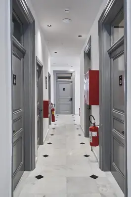 a hallway with grey doors and a tile floor at When in Athens Hostel in Athens