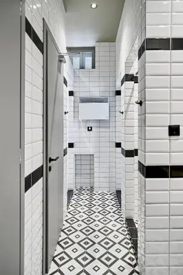 a bathroom with black and white tiles and a door at When in Athens Hostel in Athens
