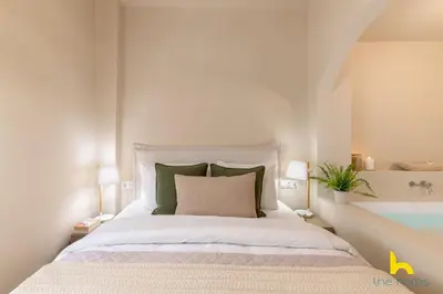 a white bedroom with a bed and a bath tub at Romantic Luxury Hideaway Near Acropolis with Jacuzzi in Athens