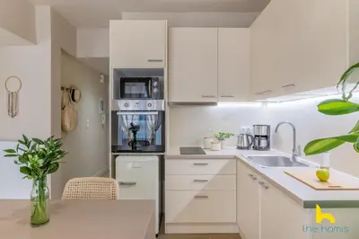 a kitchen with white cabinets and a sink at Romantic Luxury Hideaway Near Acropolis with Jacuzzi in Athens