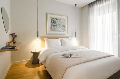 a bedroom with a white bed with a book on it at Urban APT with Stunning Acropolis View & Roofdeck in Athens