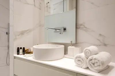 a bathroom with a sink and towels on a counter at Urban APT with Stunning Acropolis View & Roofdeck in Athens