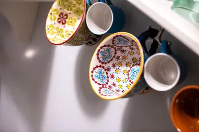 a group of cups hanging on a wall at THE CACTI HOUSE in Athens
