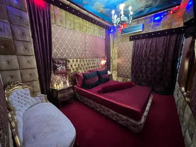 a bedroom with two beds and a chandelier at Priamos Hotel Erato in Athens