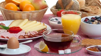 a table with a breakfast of fruit and juice at Priamos Hotel Erato in Athens