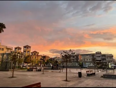 a park with benches and trees in a city at Nikaia Metro House in Piraeus