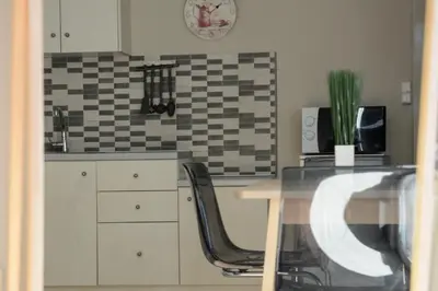a kitchen with a table and chairs and a tile wall at The frescamento.collection apartment in Athens
