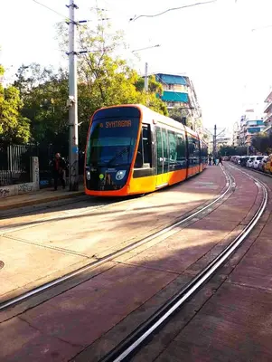 a yellow and orange train traveling down the tracks at The frescamento.collection apartment in Athens