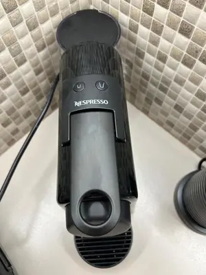 a black nintendo wii remote sitting on a bed at Bijou Kalamakiou (Athens Riviera) in Athens