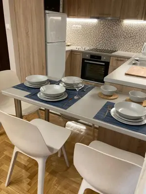 a kitchen with a table with chairs and plates on it at Bijou Kalamakiou (Athens Riviera) in Athens