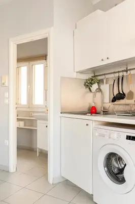 a white kitchen with a washing machine in it at Lovely APT w/heated Jacuzzi &full Acropolis view in Athens