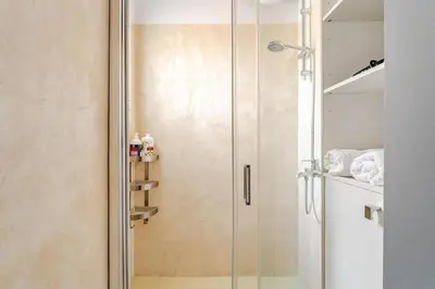 a shower with a glass door in a bathroom at Lovely APT w/heated Jacuzzi &full Acropolis view in Athens