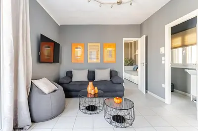 a living room with a couch and a table at Lovely APT w/heated Jacuzzi &full Acropolis view in Athens