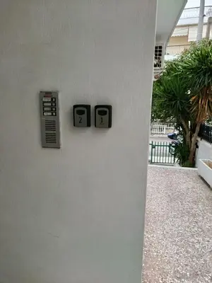 a white wall with two signs on a building at Alimos Apartments in Athens