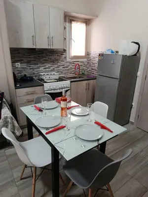 a kitchen with a table with chairs and a refrigerator at Alimos Apartments in Athens