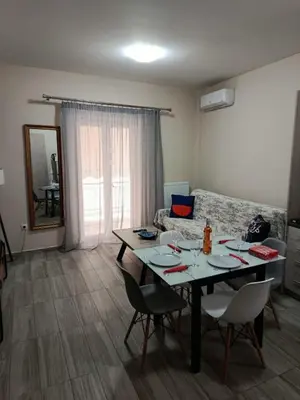 a living room with a table and chairs and a couch at Alimos Apartments in Athens