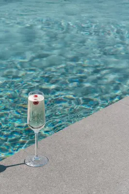 a glass of wine sitting next to the water at Neoma in Athens