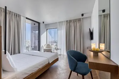 a bedroom with a bed and a desk and chairs at Neoma in Athens