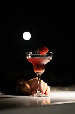 a person holding a martini with a strawberry in it at Neoma in Athens