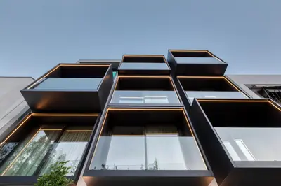 an angled view of a black building with windows at Neoma in Athens