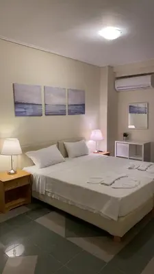 a bedroom with a large white bed with two lamps at Dina apartment in Athens