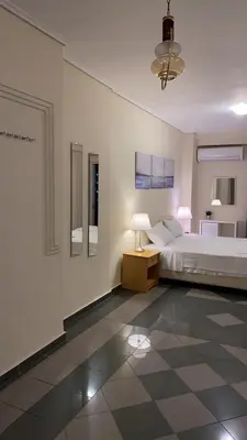 a bedroom with a bed and a lamp on a tiled floor at Dina apartment in Athens