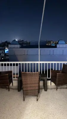 a group of chairs sitting on a balcony at night at Dina apartment in Athens