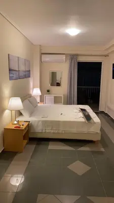 a bedroom with a bed and a table and a window at Dina apartment in Athens