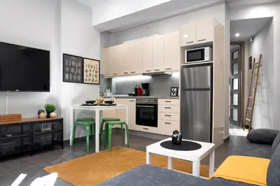 a kitchen and living room with a refrigerator and a table at New Apartment in the Heart of Plaka in Athens