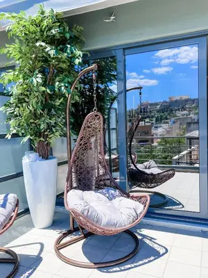 two wicker chairs are hanging on a balcony at Royalty Suites Psyrri in Athens