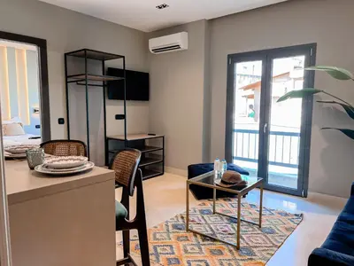 a living room with a blue couch and a table at Royalty Suites Psyrri in Athens