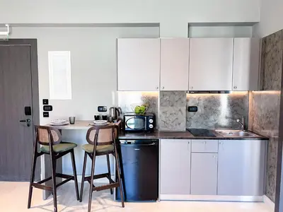 a kitchen with white cabinets and a table and chairs at Royalty Suites Psyrri in Athens