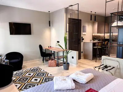 a room with a bed and a table and a kitchen at Royalty Suites Psyrri in Athens