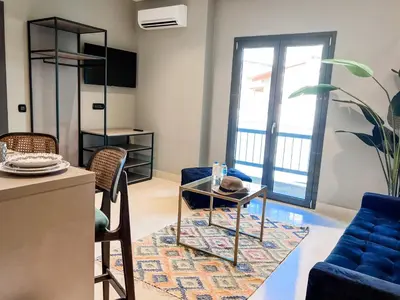 a living room with a blue couch and a table at Royalty Suites Psyrri in Athens