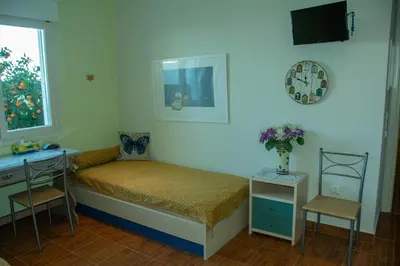 a bedroom with a bed and a desk and a television at Maya's home in Dhaskalión