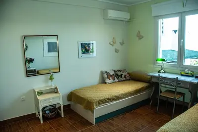 a bedroom with a bed and a desk and a mirror at Maya's home in Dhaskalión