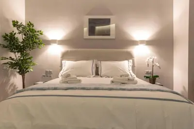 a bedroom with a white bed with two towels on it at A11 Pristine & comfy studio near Plaka & Parthenon in Athens