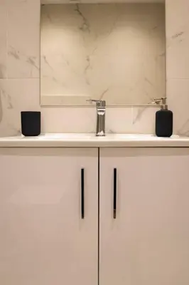 a white bathroom with a sink and a mirror at A11 Pristine & comfy studio near Plaka & Parthenon in Athens