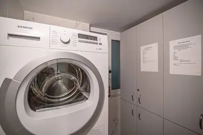 a white washing machine in a room with cabinets at A13 Pristine & Sunny 30m2 flat near Syntagma sq in Athens