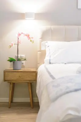 a bedroom with a bed and a table with a plant on it at A13 Pristine & Sunny 30m2 flat near Syntagma sq in Athens