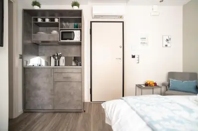 a small bedroom with a bed and a kitchen at A13 Pristine & Sunny 30m2 flat near Syntagma sq in Athens
