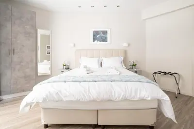 a white bedroom with a large bed with white sheets at A16 Premium suite near Plaka in Athens center in Athens