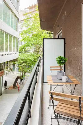 a table and benches on a balcony with a whiteboard at A16 Premium suite near Plaka in Athens center in Athens