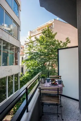 a balcony with a table and a white screen at A24 Pristine & sunny suite near Plaka & Parthenon in Athens