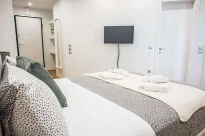 a bedroom with a bed with a tv on the wall at A24 Pristine & sunny suite near Plaka & Parthenon in Athens