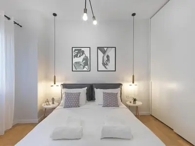 a white bedroom with a large bed with two tables at FRESH, NEW & READY FOR YOU! RNVTD APT IN KOUKAKI! in Athens