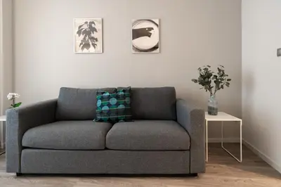 a gray couch in a living room with a table at A12 Pristine 1bedrooom flat near Parthenon in Athens' heart in Athens